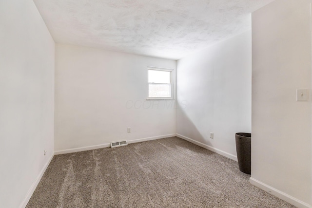 unfurnished room featuring a textured ceiling and carpet