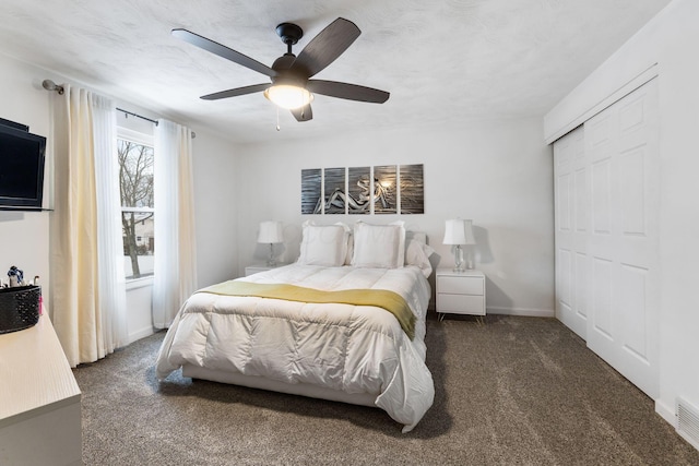 bedroom featuring ceiling fan, dark carpet, and a closet