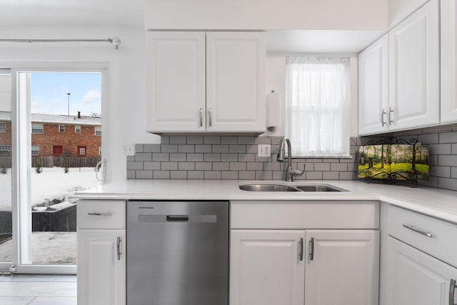 kitchen with sink, white cabinetry, backsplash, and dishwasher