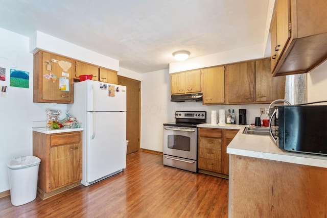 kitchen featuring dark wood-type flooring, sink, stainless steel electric range oven, and white fridge