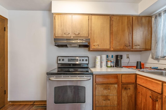 kitchen with stainless steel electric range oven, dark wood-type flooring, and sink