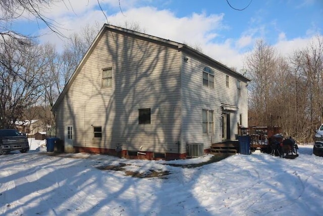 snow covered property with cooling unit