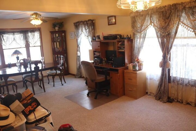 carpeted home office with ceiling fan with notable chandelier