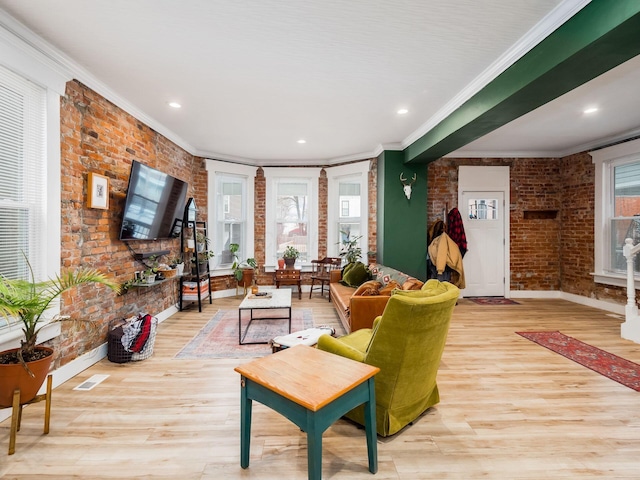 living room with light wood-type flooring, brick wall, and ornamental molding