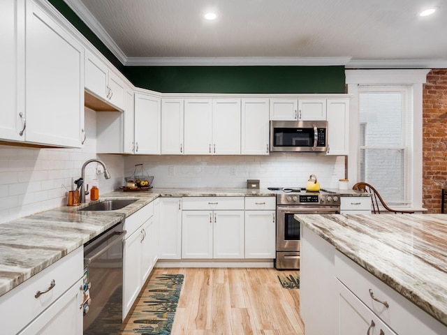 kitchen featuring sink, white cabinets, decorative backsplash, and appliances with stainless steel finishes