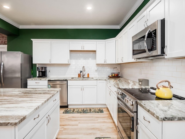 kitchen featuring sink, stainless steel appliances, white cabinets, and decorative backsplash