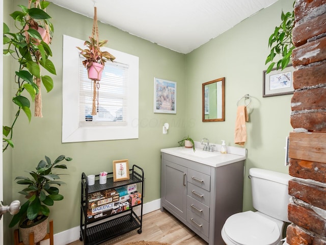 bathroom with hardwood / wood-style flooring, toilet, and vanity