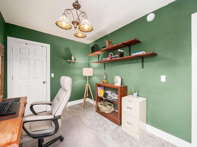 carpeted home office featuring an inviting chandelier