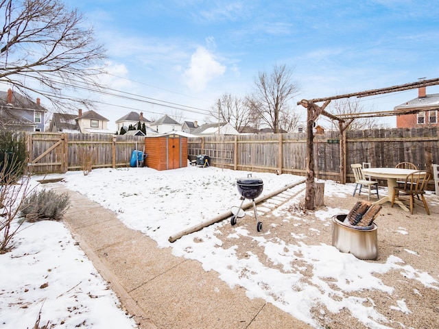 yard covered in snow featuring a storage unit