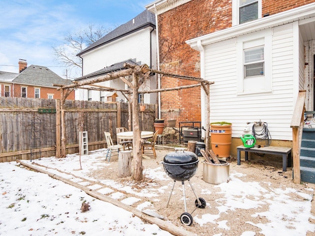 snow covered patio featuring an outdoor fire pit