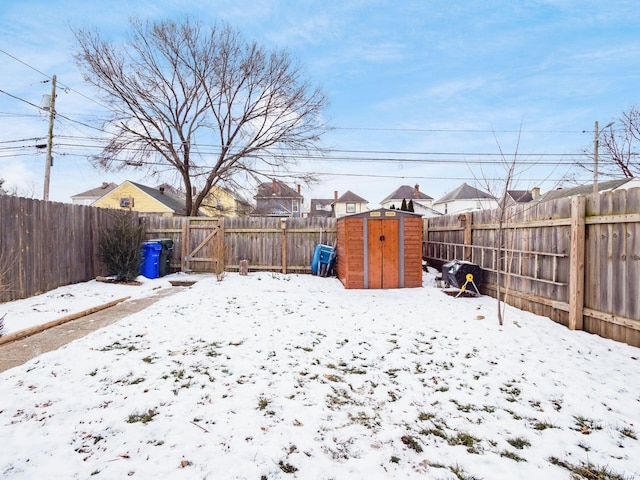 yard layered in snow featuring a storage unit