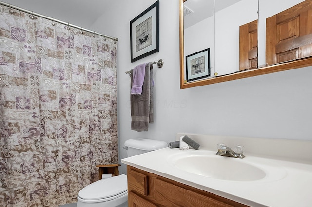 bathroom featuring a shower with curtain, vanity, and toilet