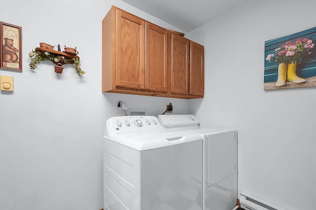 clothes washing area featuring washing machine and dryer, cabinets, and a baseboard radiator