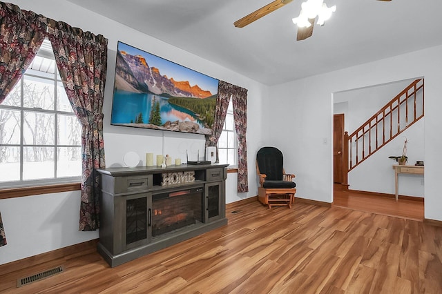 living room with light wood-type flooring and ceiling fan