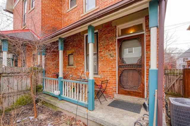 view of exterior entry with central air condition unit and covered porch