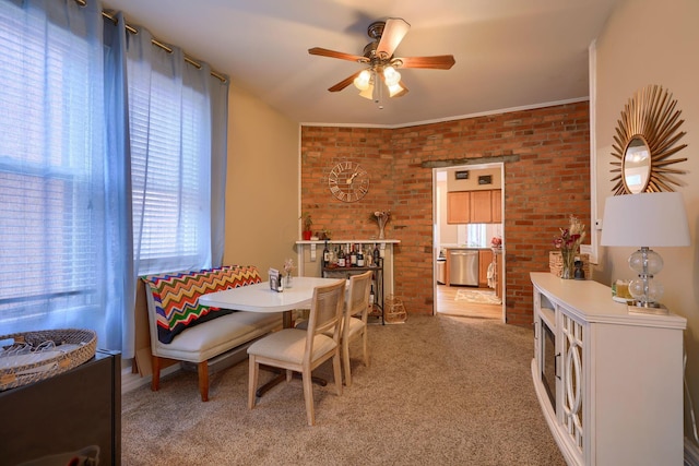 dining room with carpet, ceiling fan, and brick wall