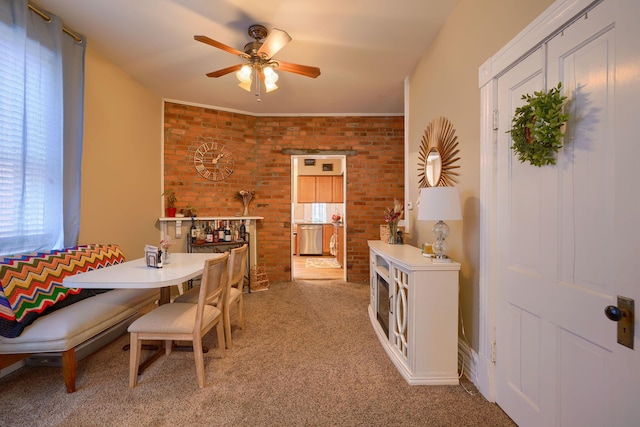 carpeted dining room with brick wall and ceiling fan