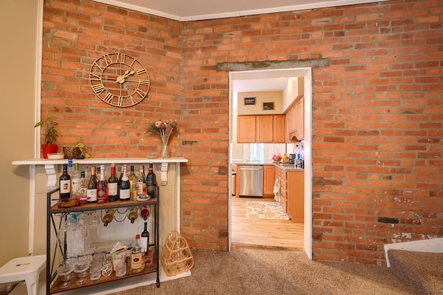 interior space featuring brick wall, ornamental molding, dishwasher, and carpet