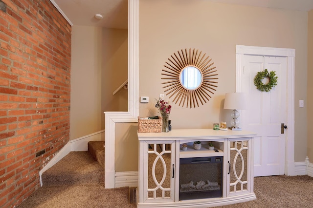 interior space with brick wall and carpet flooring