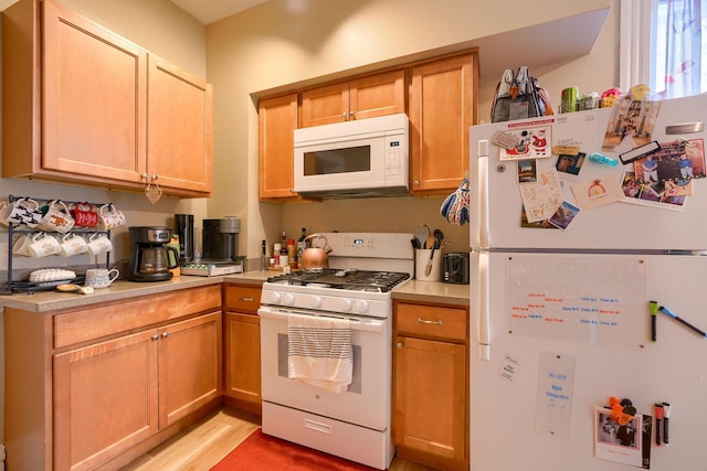 kitchen with light wood-type flooring and white appliances