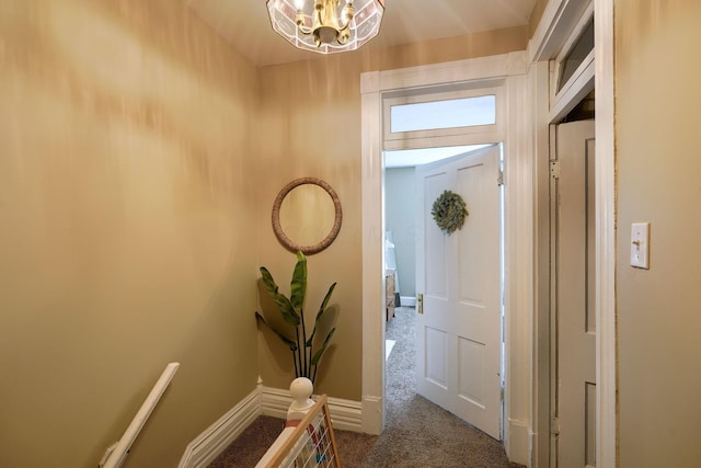 hall featuring a notable chandelier and carpet floors