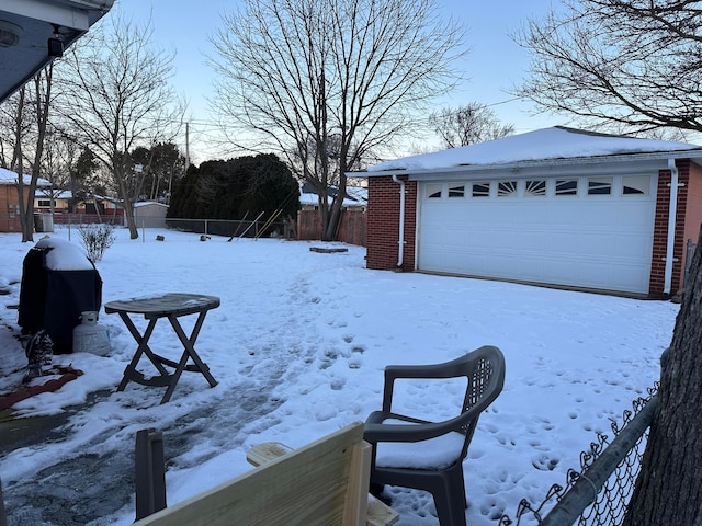 yard layered in snow featuring a garage