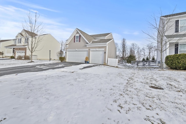 snow covered property with a garage