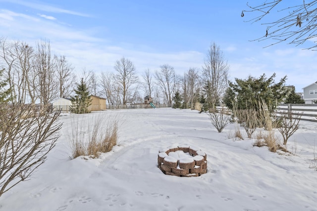 yard layered in snow featuring an outdoor fire pit