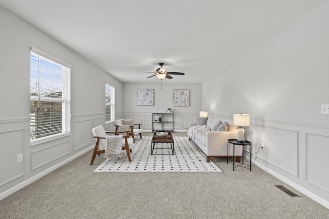 carpeted living room with ceiling fan