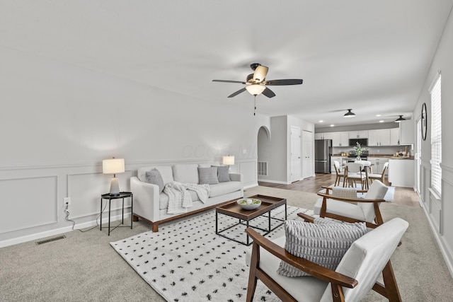 carpeted living room with ceiling fan