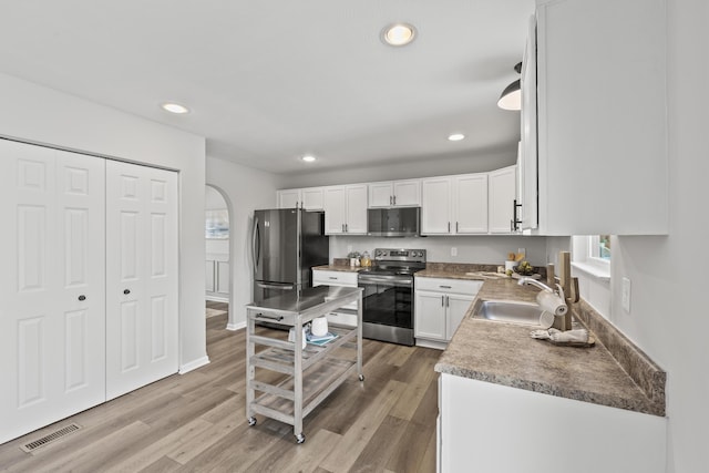 kitchen featuring sink, light wood-type flooring, white cabinetry, and stainless steel appliances