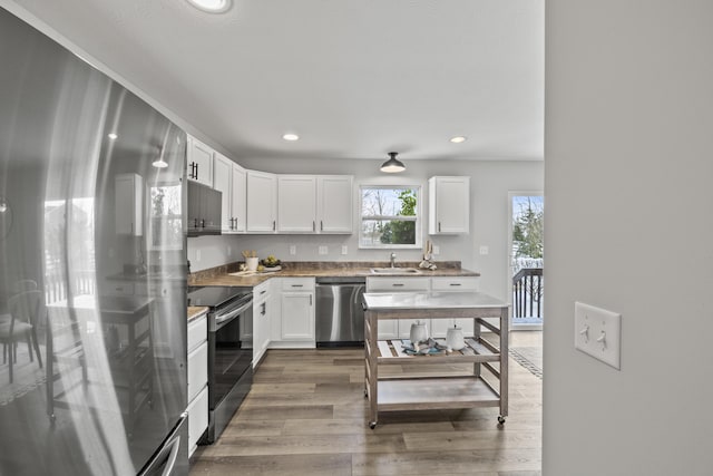 kitchen with sink, white cabinetry, appliances with stainless steel finishes, and dark hardwood / wood-style floors