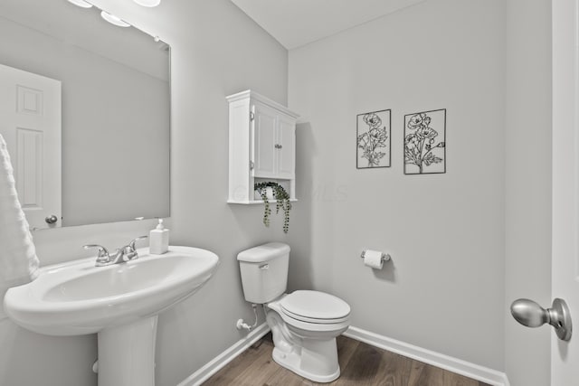 bathroom with hardwood / wood-style floors and toilet