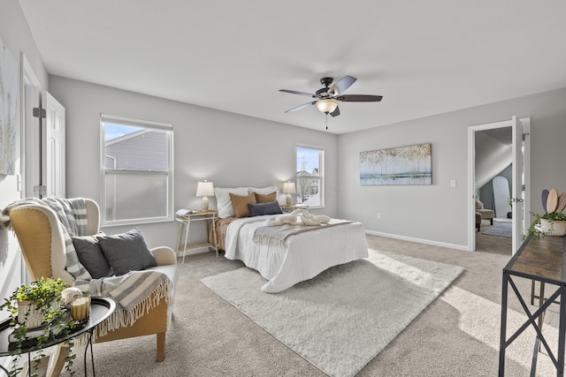 bedroom featuring ceiling fan, light colored carpet, and multiple windows