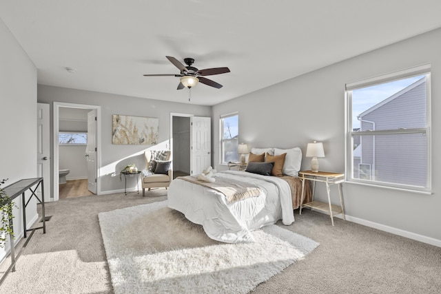 bedroom featuring ceiling fan, ensuite bathroom, and light carpet