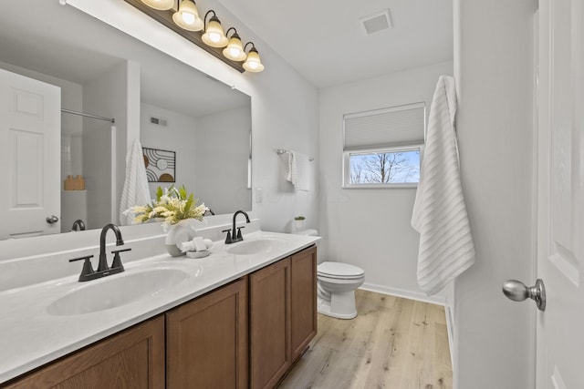 bathroom featuring wood-type flooring, toilet, and vanity