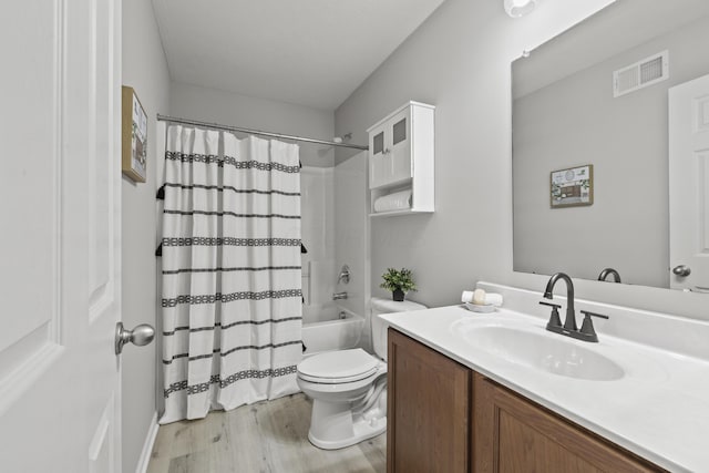 full bathroom with hardwood / wood-style floors, toilet, vanity, and shower / bathtub combination with curtain