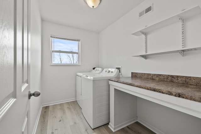 washroom with separate washer and dryer and light wood-type flooring