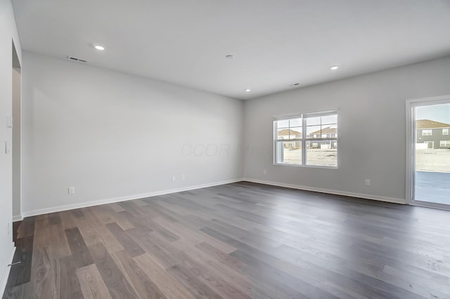 spare room featuring dark wood finished floors, recessed lighting, baseboards, and visible vents