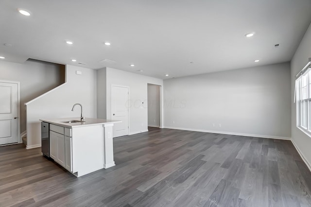 kitchen featuring dark wood-type flooring, an island with sink, recessed lighting, and a sink