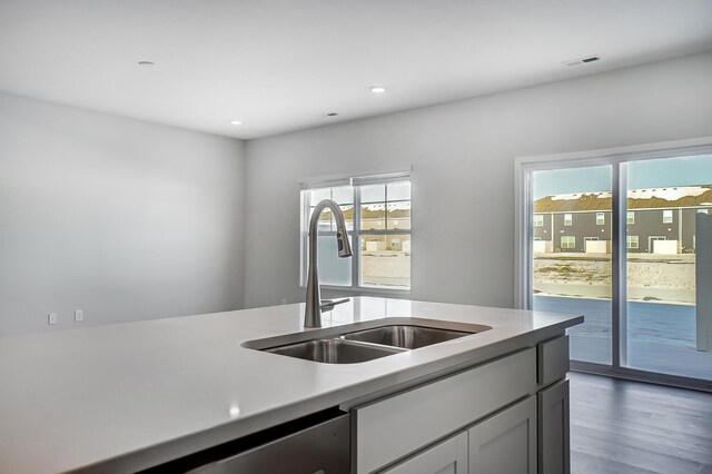 kitchen featuring wood finished floors, visible vents, recessed lighting, a sink, and light countertops