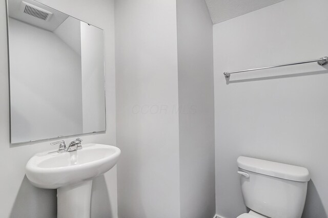 half bathroom featuring visible vents and toilet