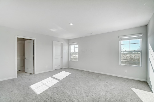 unfurnished bedroom with light colored carpet and baseboards