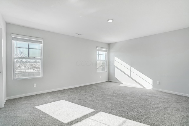 carpeted empty room with visible vents and baseboards