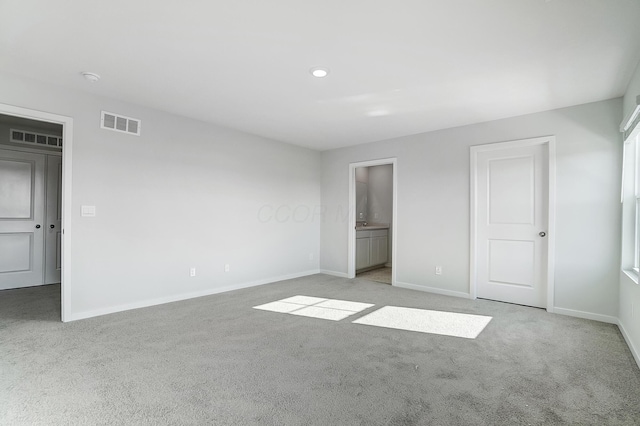 unfurnished bedroom featuring visible vents, light colored carpet, and baseboards