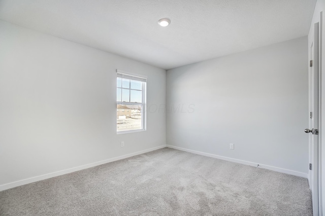 carpeted empty room with baseboards