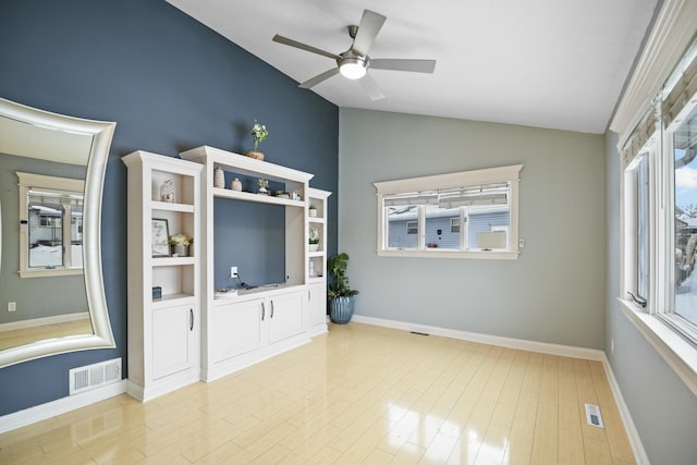 unfurnished living room featuring ceiling fan, a healthy amount of sunlight, vaulted ceiling, and light hardwood / wood-style floors