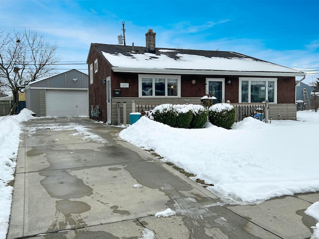 view of front of home with a garage and an outbuilding