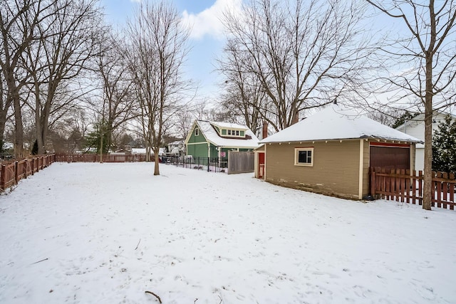 yard covered in snow featuring an outdoor structure and a garage