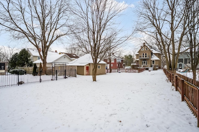 yard layered in snow with an outbuilding